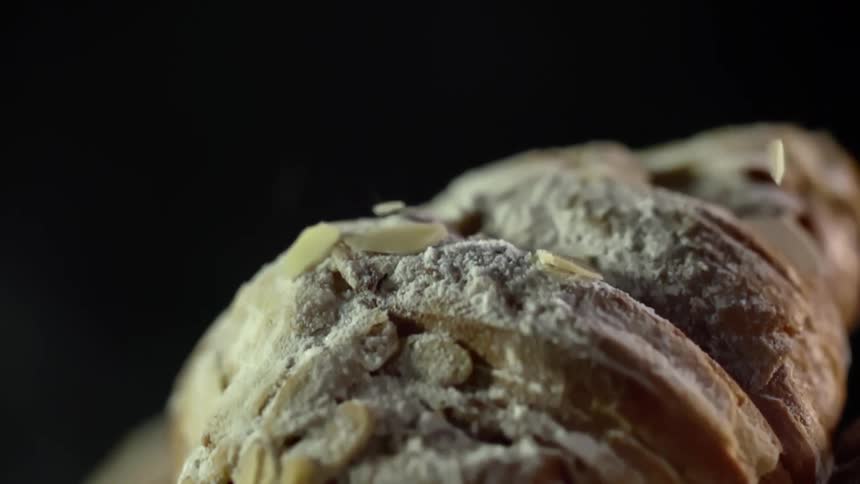 Toppings are sprinkled onto a pastry