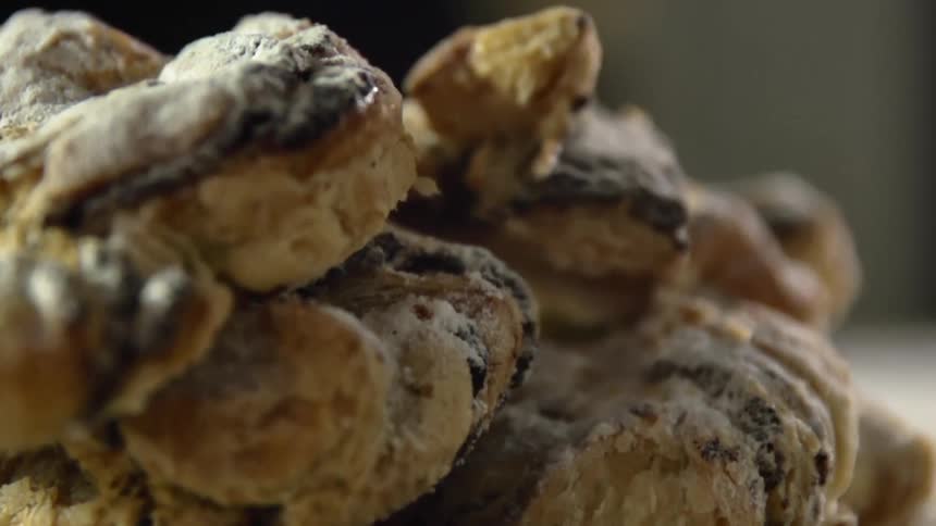 Pile of sweet baked rolls covered in confectioners sugar