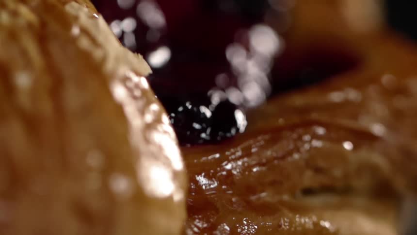 Pieces of dark fruit sit on a pastry
