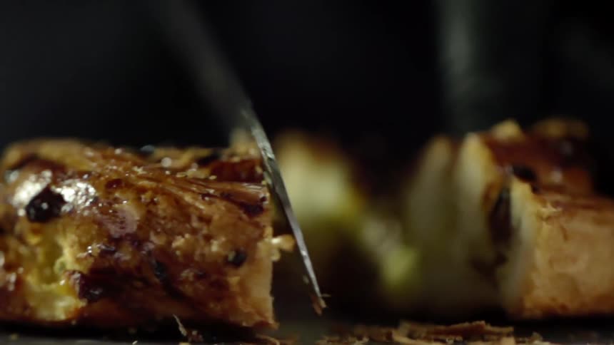 A person cuts a pastry in half