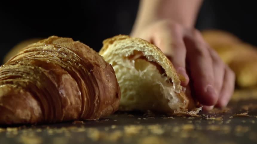 A person pulls the croissant apart