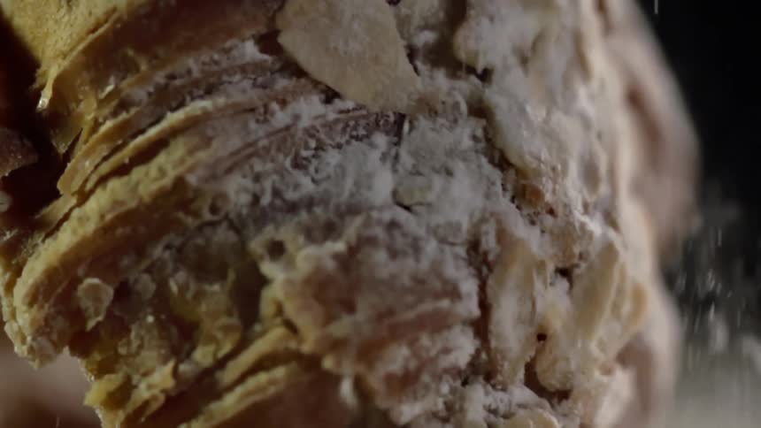 Flour pours off a loaf of bread as it is placed down