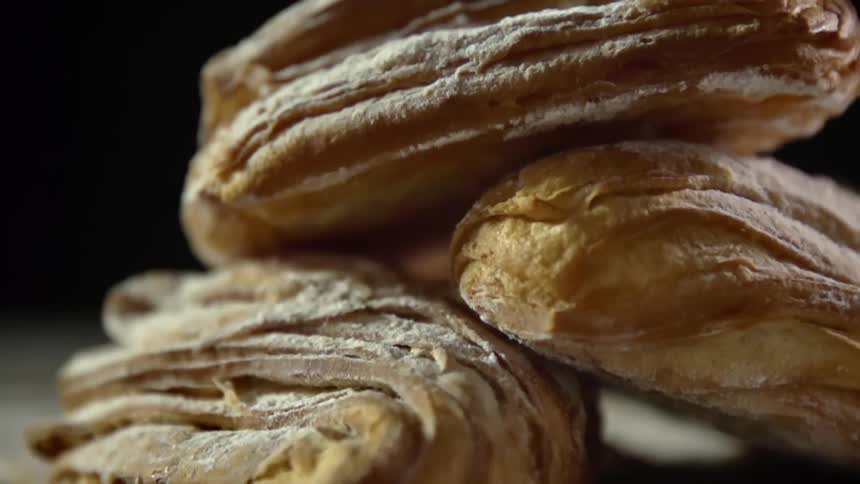 Close uo of a pile of croissants covered in confectionary sugar