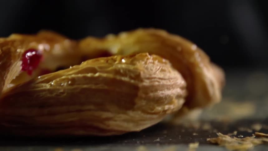 A bread pastry falls down onto a table top