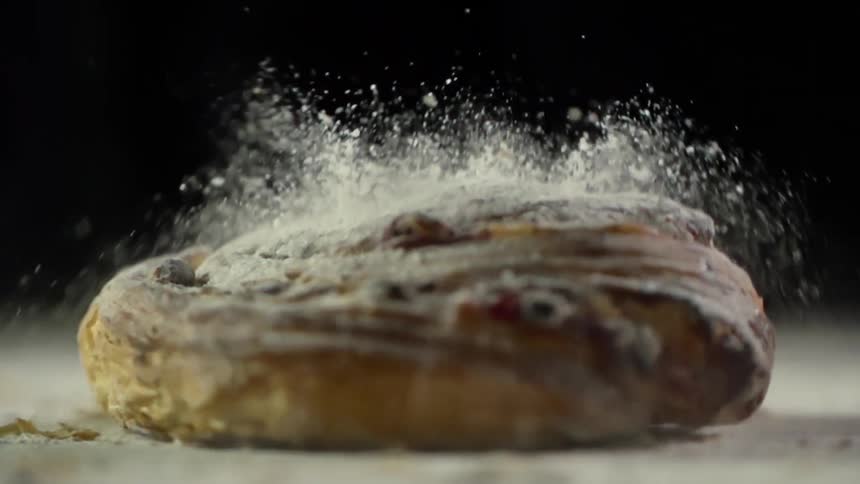 Powdered sugar falls off a baked good as it drops to the counter