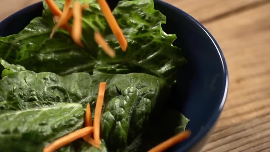 Carrots strips are dropped in the salad