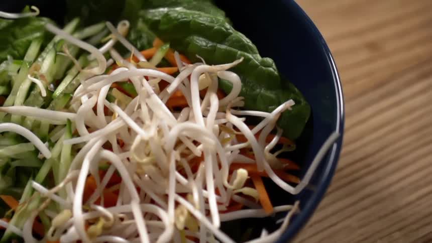 Vegetables are dropped in a stir fry pan