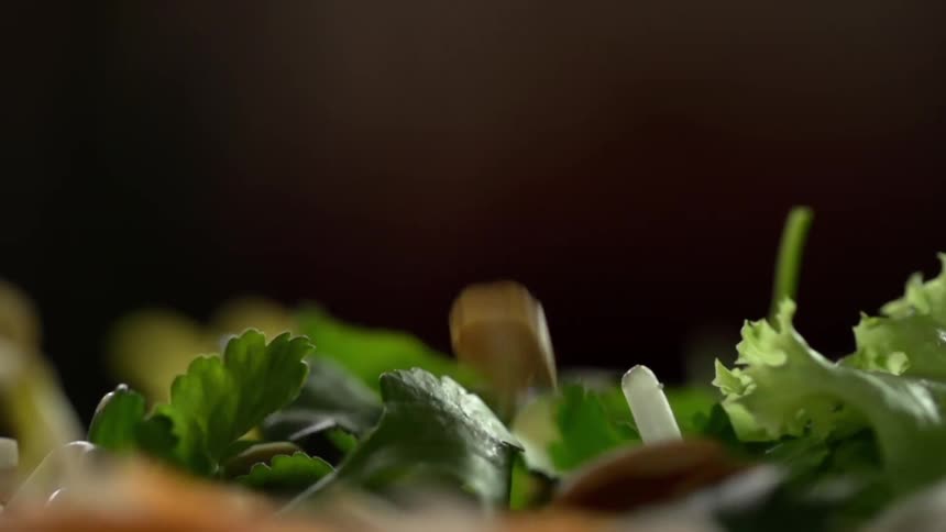 Nuts falling into a salad plate