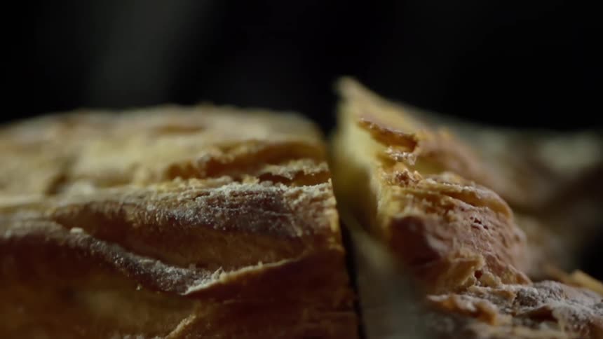Kitchen knife cutting a crumbly pastry in half