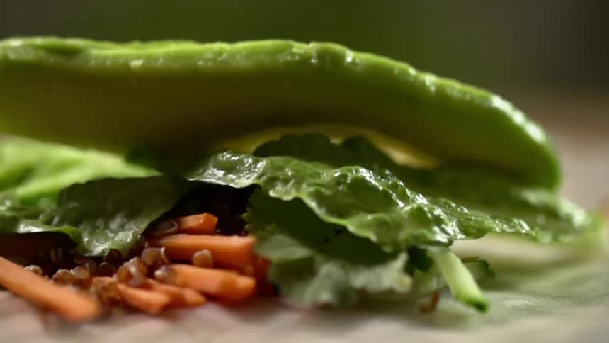 Avocado slices falls on top of lettuce leafs over burrito filling
