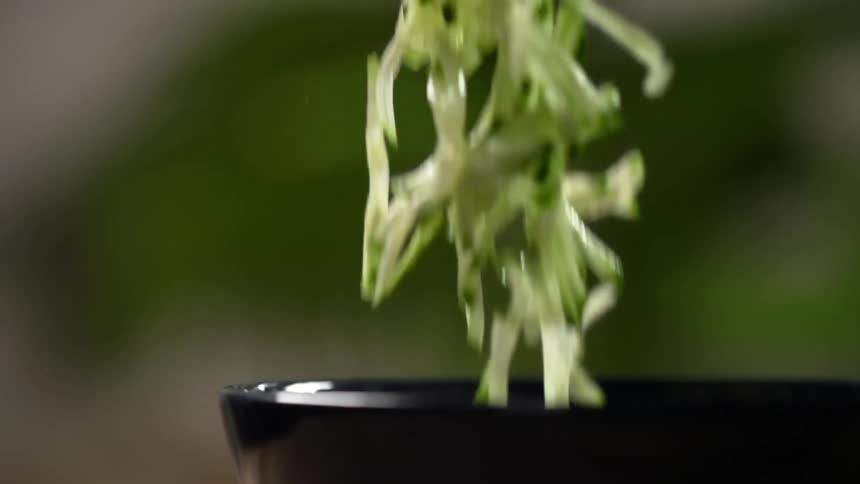 Vegetables are dropped into the bowl