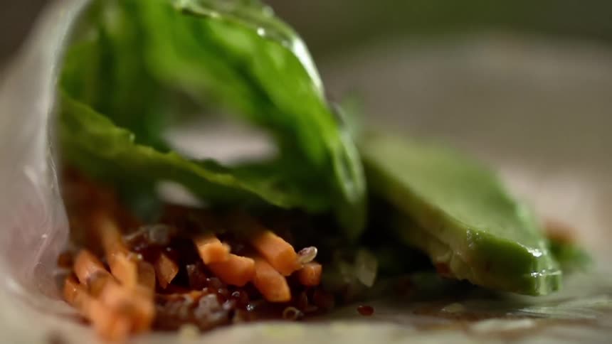 Avocado and lettuce is rolled up into a food wrap