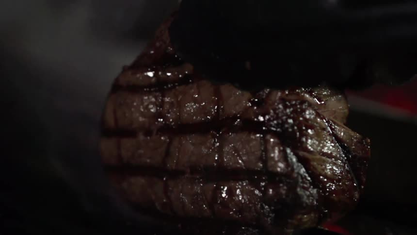A piece of steak is being grilled
