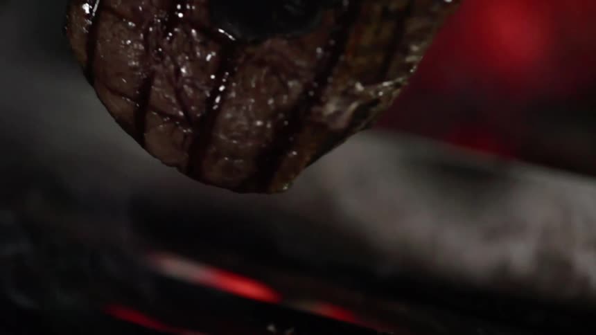 Beef is cooked and turned on a hot grill