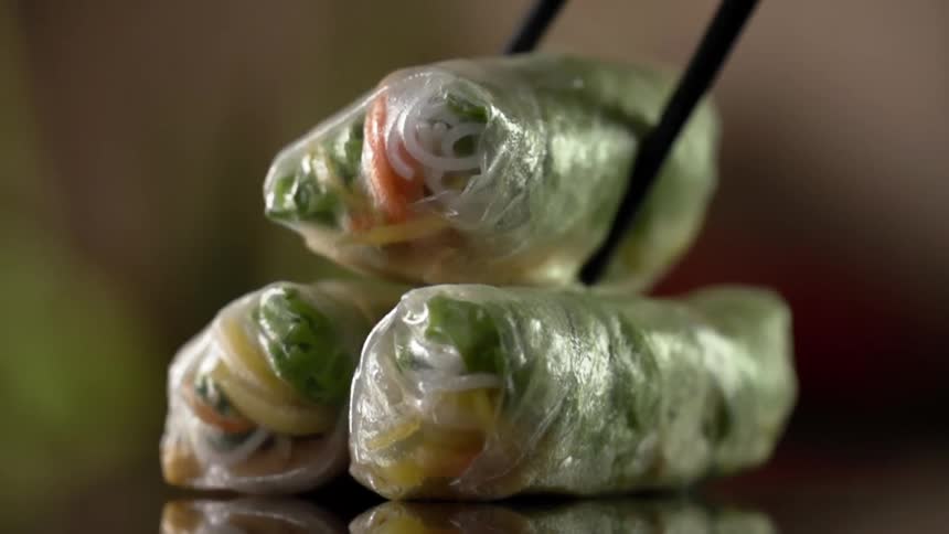 A spring roll is set on top of two spring rolls
