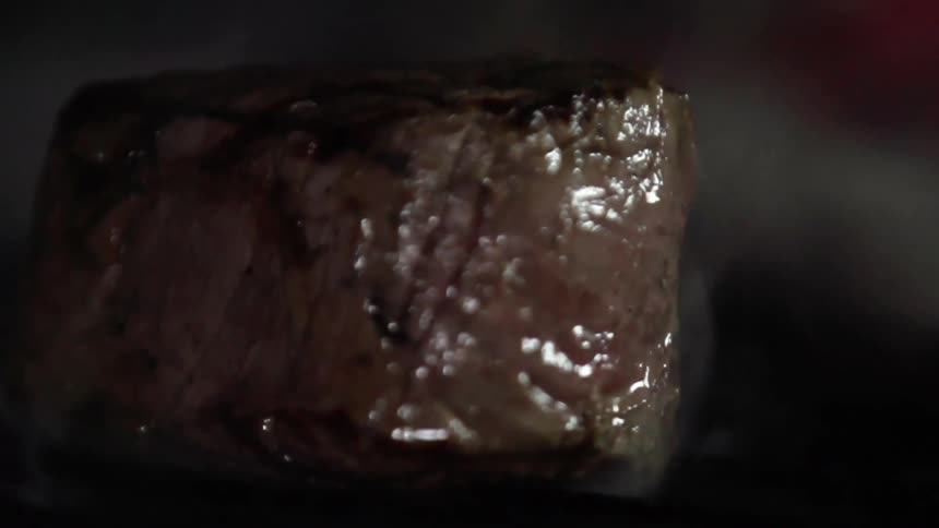 Thick grilled steak bounces being served still smoking