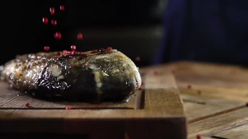 Red seasonings drop on a piece of fish