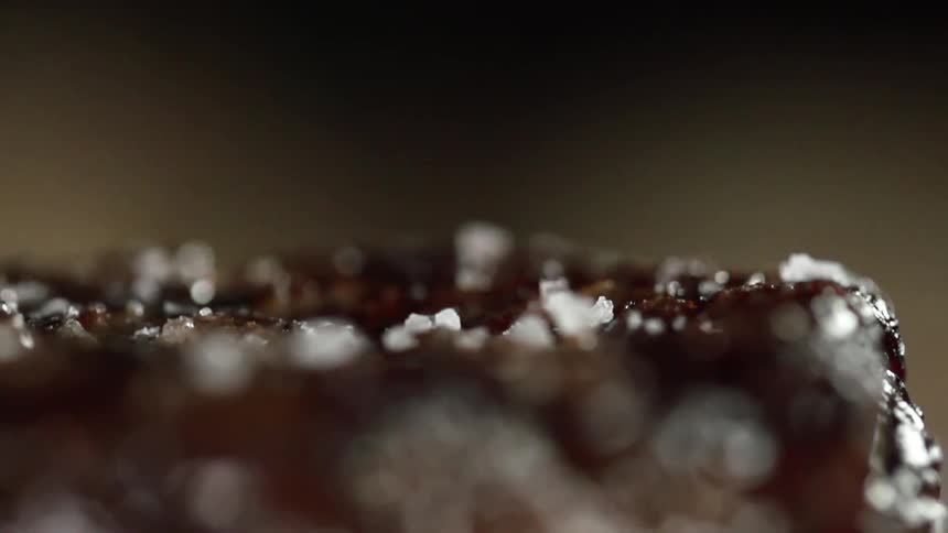 Salt is added to a grilled steak