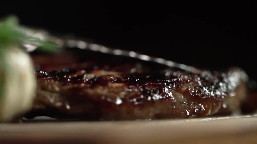 Juicy steak is being put on a steak board
