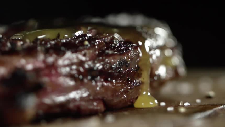 A yellow sauce poured over a finished steak