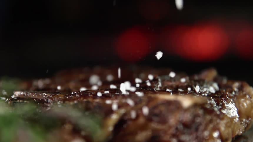 Salt being sprinkled on a cooked steak
