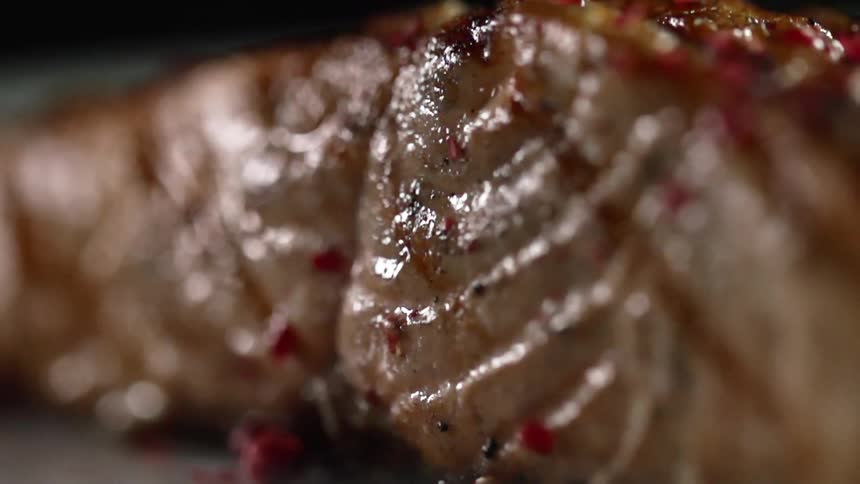 Seasoning bits cling to a cooked piece of steak