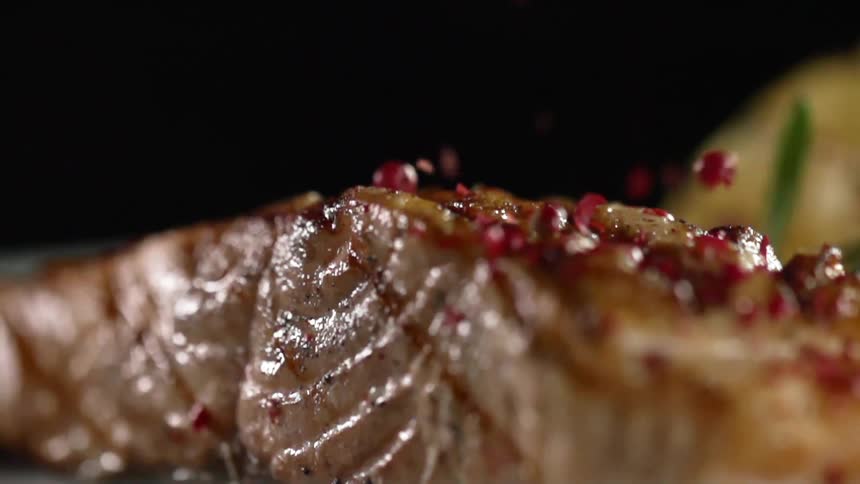 Cooked fish fillet garnished with red crushed seasoning