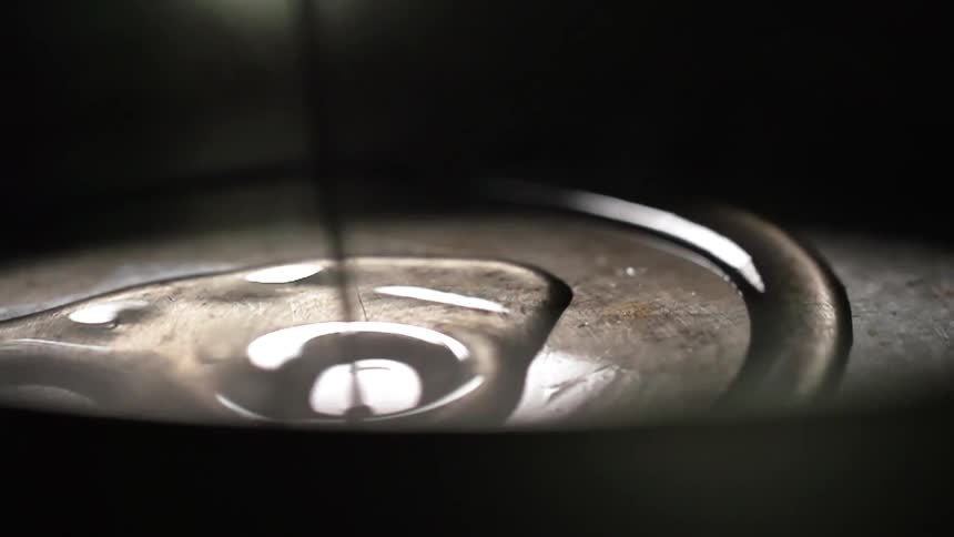 Oil is poured into a pan as it pools then drips