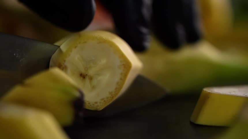 A person cutting a banana
