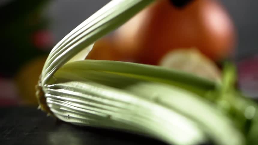 A piece of celery is pulled form the stalk