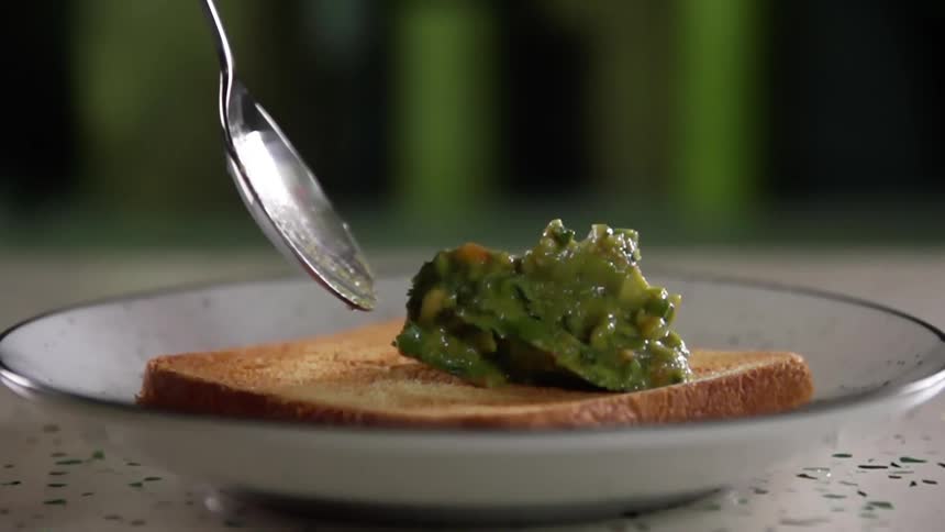 Guacamole being put on toast