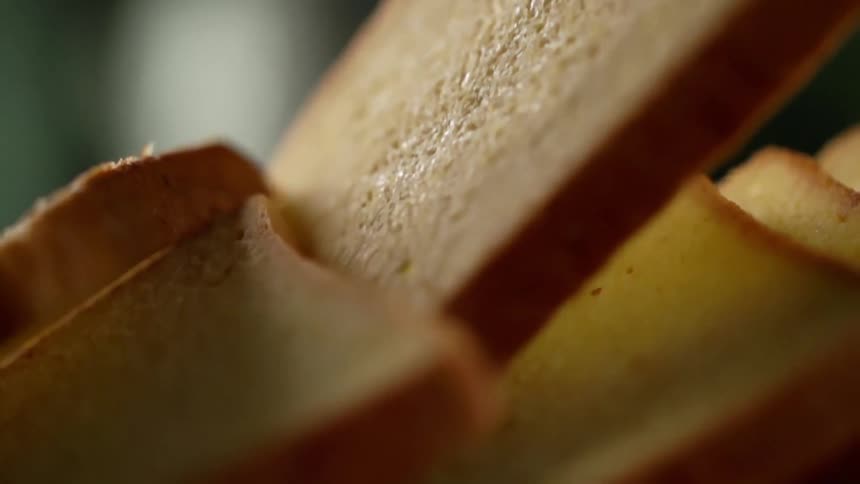 A person picks up a piece of bread