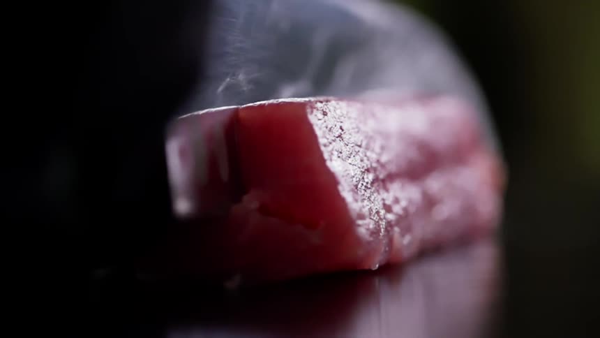 A knife is used to cut the piece of fish
