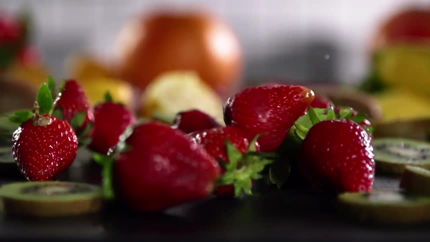 Close up of strawberries falling on the ground next to the fruits