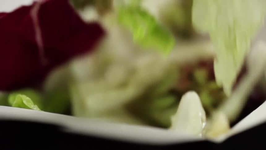 Slices of cabbage fall into the top of a white cardboard box