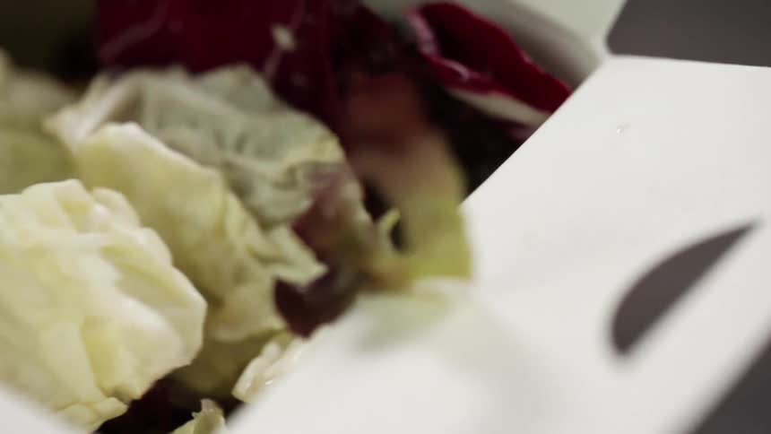 Lettuce falls into a takeout box