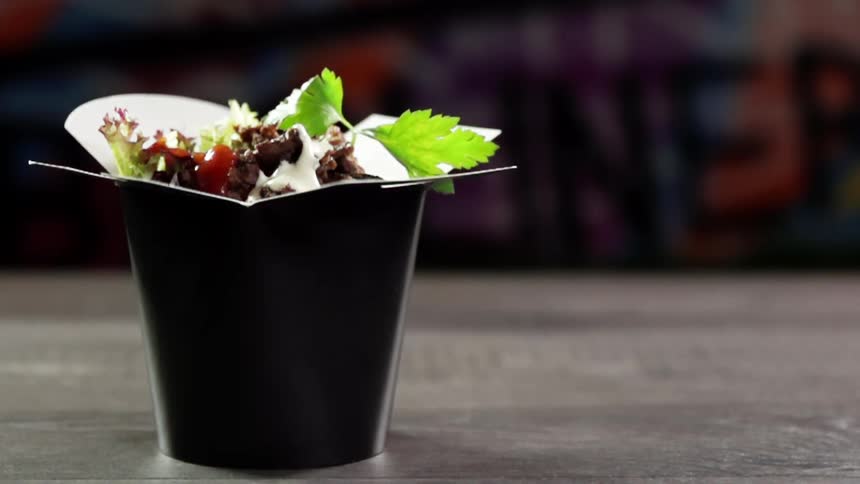 A garnish is put on top of food in a take out box