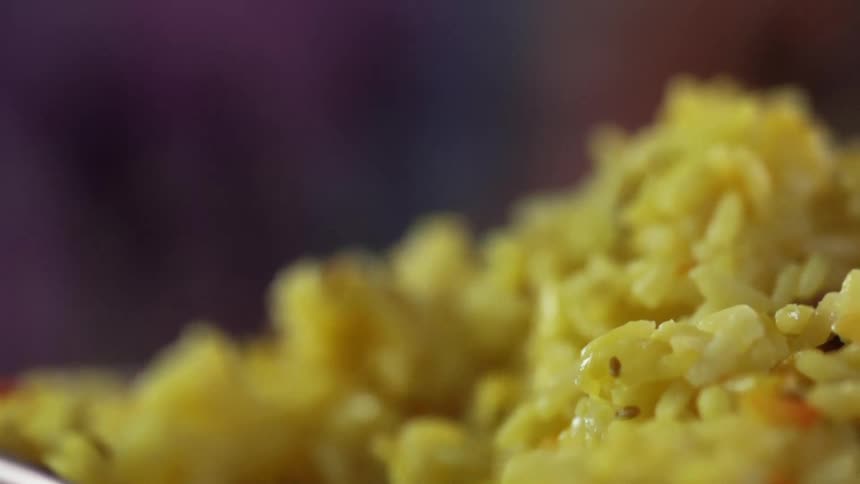 Yellow rice is being scooped to serve