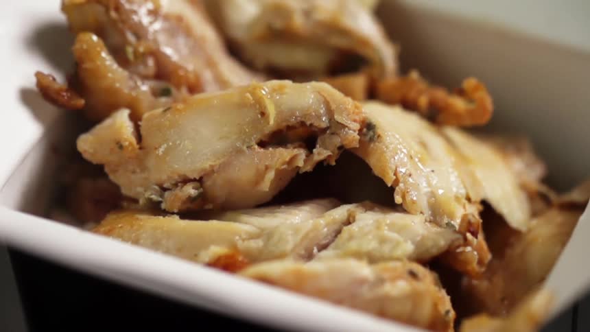 Cooked meat falls into a takeout container