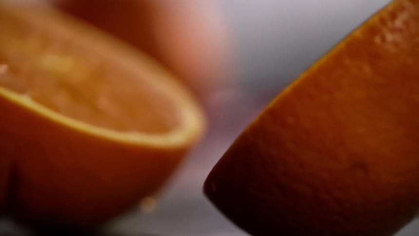 Two pieces of orange fall and roll around