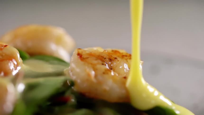 Sauce being poured over top of shrimp