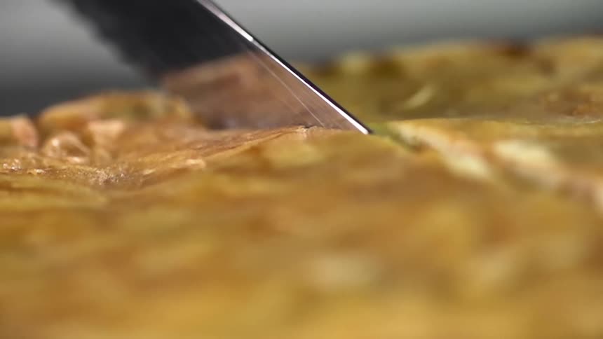 Close up of a cake being cut by a bread knife