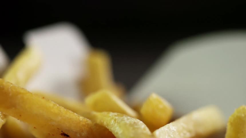 French fries fall into a takeout container