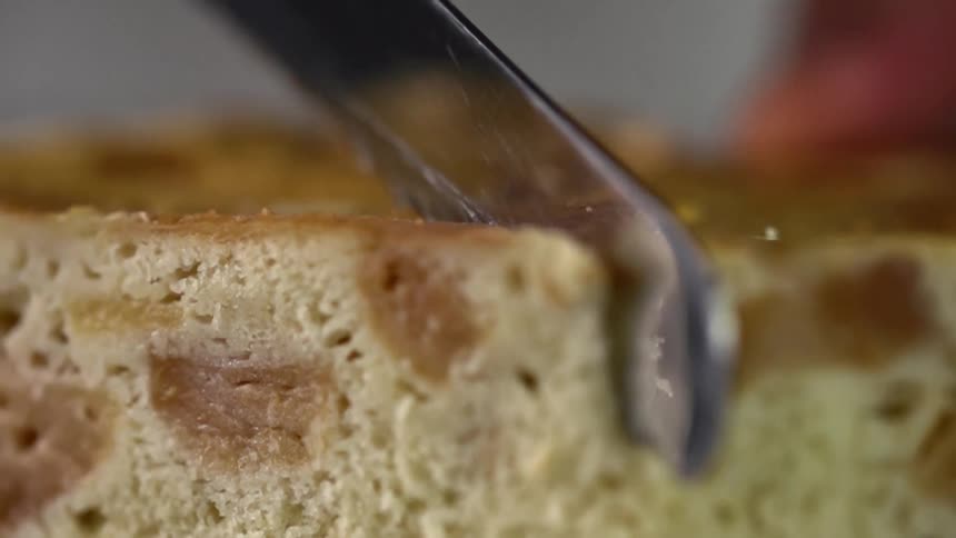 Close up of cornbread being cut by a bread knife