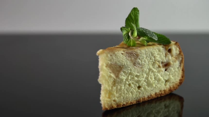 A garnish is dropped on a piece of cake in a studio