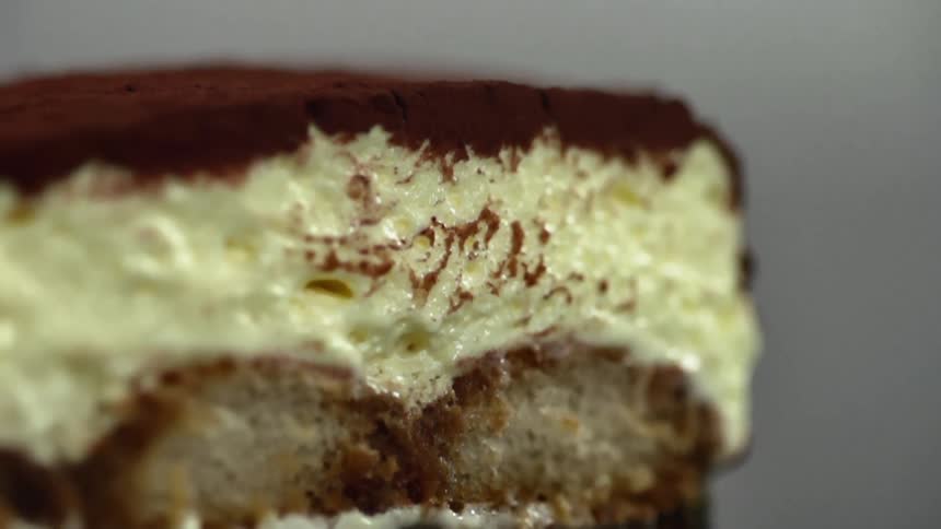 Slice of cake with cream icing and powdered chocolate