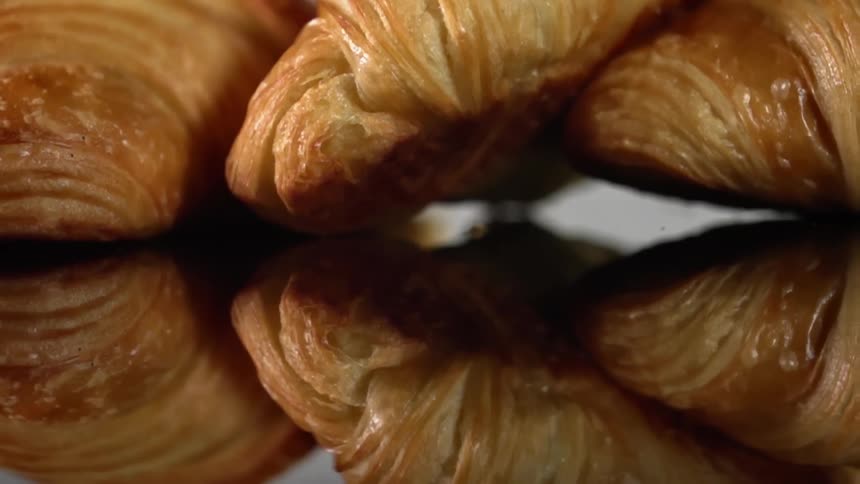 Croissants sit on a reflective surface