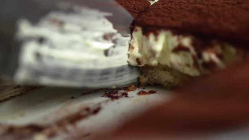 A knife pulling out of a dessert after cutting it