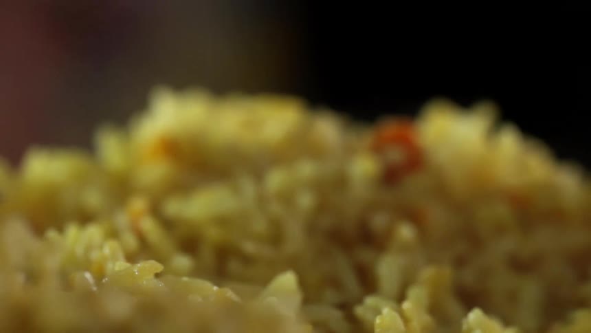 A spoon scooping rice and vegetables