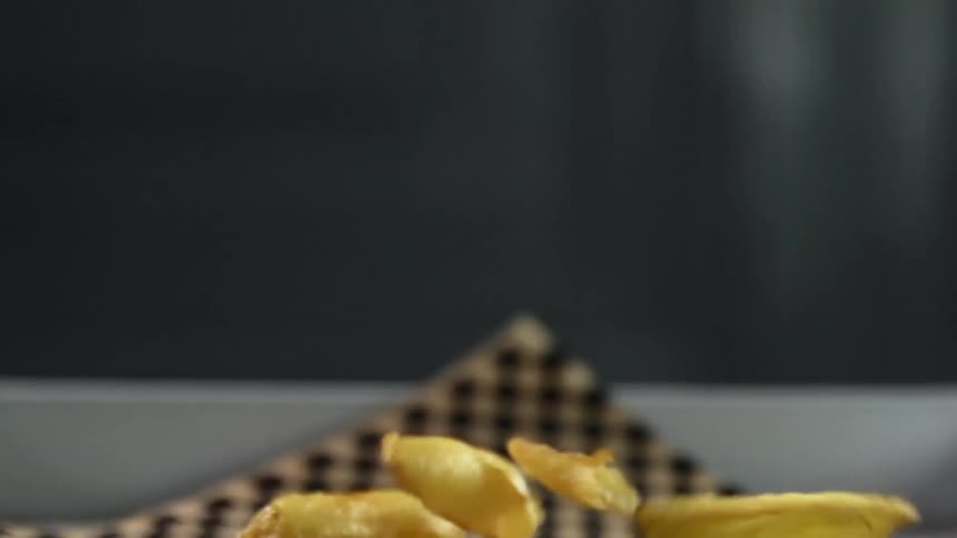 Golden french fries in a plate over the table
